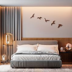 a large bed sitting in a bedroom next to a wall with birds flying above it