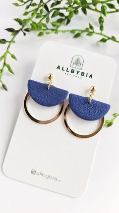 a pair of blue and gold hoop earrings sitting on top of a white card