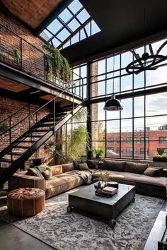 a living room filled with lots of furniture next to tall windows and a stair case