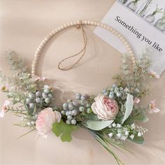 a wreath with flowers and greenery hanging on a wall