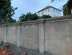 a concrete fence with some trees in the background