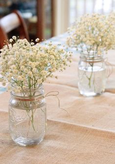 two mason jars filled with baby's breath flowers