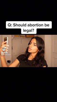 a woman holding a cell phone in her right hand and the caption says, q should abotn be legal?