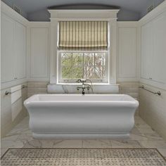 a bath tub sitting under a window in a bathroom