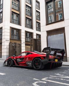 a red sports car parked in front of a tall building