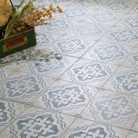 a vase filled with flowers sitting on top of a tiled floor