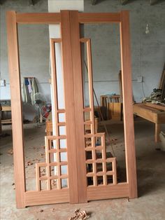 two wooden doors in the middle of a room with wood flooring and unfinished furniture