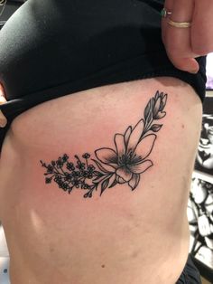 a woman's stomach with a flower tattoo on her belly and the bottom part of her lower back