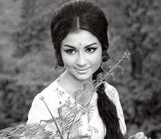 an old photo of a woman with long hair holding a plant in her right hand