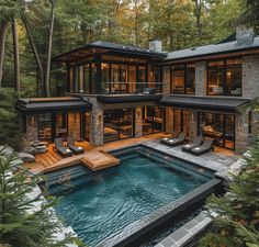 this is an image of a modern house in the woods with a pool and hot tub