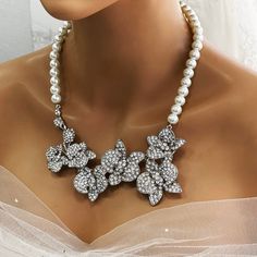 Elevate your bridal look with our Bridal Statement Earrings Necklace Set. Crafted with stunning crystal pearls and intricate orchid flowers, this unique wedding jewelry set adds a touch of elegance to your special day. Designed as the perfect gift for brides, each piece reflects meticulous attention to detail and timeless beauty. Let our set be a cherished part of your unforgettable moments. Embrace authenticity and sparkle with this exquisite ensemble. Dazzle on your special day with our exquis Silver Pearl Bridal Accessories For Bride, Silver Pearl Bridal Accessories, White Flower Bridal Necklace For Wedding, White Floral Bridal Necklace For Wedding, Pearl White Crystal Bridal Necklace For Wedding, Pearl White Crystal Bridal Earrings For Wedding, Pearl Flower Jewelry For Wedding, Silver Flower Bridal Necklace For Wedding, Flower-shaped Pearl Jewelry For Wedding