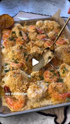 a person is spooning some food out of a casserole dish with shrimp and bread crumbs