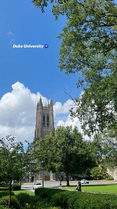 a large cathedral towering over a lush green park filled with lots of trees and shrubbery