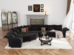 a living room filled with black couches and pillows on top of a wooden floor