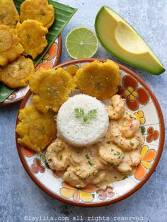 a plate with rice, meat and vegetables on it next to sliced avocado