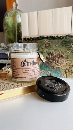 a jar of butterbeet sitting on top of a table next to a book