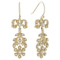 These dangling earrings showcase a delightful floral motif crafted from yellow gold frames. At the top, charming round white pearls in a gold ribbon shape enhances the overall aesthetic with its delicate detail. Towards the bottom, round white pearls delicately form petals and leaves, reminiscent of blooming clusters of flowers. Each earring is adorned with round white pearls in bead settings, accentuating the elegance of the design and adding a touch of luxury. CHARACTERISTICS Status: Made to o Intricate Yellow Gold Dangle Earrings, Vintage Yellow Gold Flower Shaped Earrings, Luxury Yellow Gold Victorian Pearl Earrings, Vintage Gold Flower-shaped Earrings, Elegant Yellow Gold Flower-shaped Pearl Earrings, Vintage Inspired Earrings, Pearl Vintage, Gold Frames, Earring Box