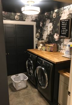 a washer and dryer in a small room with floral wallpaper on the walls