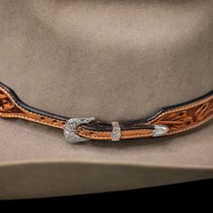 The Deluxe Sheridan Hatband is a 1" thick hatband with a tapered sterling silver buckle. The russet hatband is hand tooled with our classic Sheridan floral design, and also features stitched edges, creating a bold hatband for the bold cowboys. Measures: 26 1/2" from third hole Elegant Brown Hat Band For Ranch, Silver Western Hat Band For Rodeo, Silver Western Hat For Western-themed Events, Western Silver Hats For Western-themed Events, Adjustable Silver Hat Band For Rodeo, Western Adjustable Silver Hat Band, Western Style Silver Adjustable Hat Band, Western Hat Band With Leather Sweatband For Western-themed Events, Western Hat Bands With Leather Sweatband For Western-themed Events