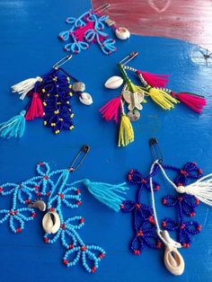 several different colored beads and tassels on a blue surface