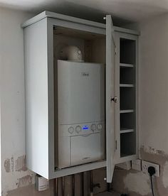 a white cabinet sitting on top of a floor next to a wall mounted air conditioner