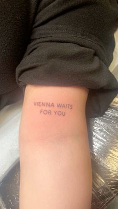 a woman's arm with the words vienna waits for you tattooed on her left side