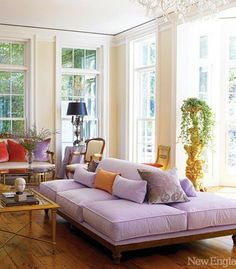 a living room filled with furniture and lots of windows