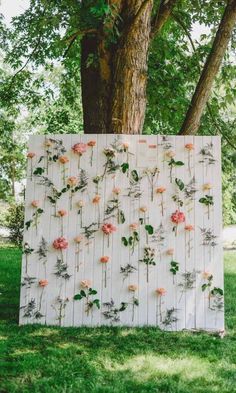 an art piece with flowers on it in front of a tree