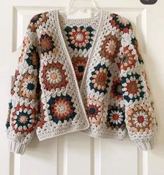 a crocheted jacket hanging on a door