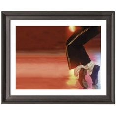 a framed photograph of a figure skating on the ice