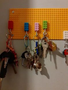 several keys are hanging on a lego key holder