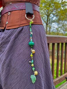 Belt bells are a form of gender-neutral jewelry, often found at renaissance festivals, that go by many names (folly bells, belt beads, jingles, jinglies). These beaded strands are fun to fidget with and are sensory friendly- it's jewelry that doesn't touch your skin! They are made to fit belts up to 2 inches wide, and are the perfect accessory to take your fantasy outfit or everyday wear to the next level. Many of the materials used to make this jewelry, including the leather and the metal rings, are upcycled or recycled from other uses! Ren Fest Accessories, Cosplay Accessories Ideas, Fun Things To Do With Beads, Gender Neutral Jewelry, Ren Faire Jewelry, Ren Faire Accessories Diy, Ren Fair Accessories, Renfaire Accessories