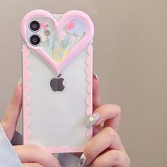 a person holding an iphone in their hand with a heart shaped case on it's back