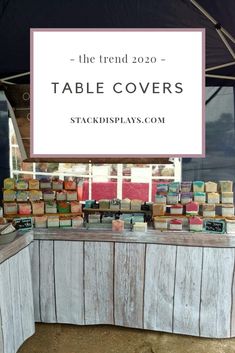 a table covered in lots of books under a tent with a sign that says craft show treats