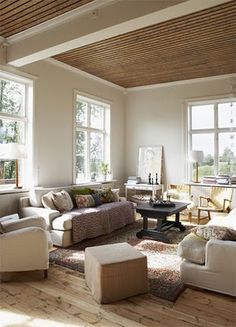 a living room filled with furniture and lots of windows