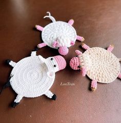 three crocheted sheep sitting next to each other on a table