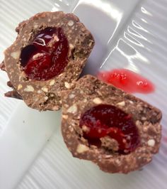 two pastries with jelly and nuts are on a plate