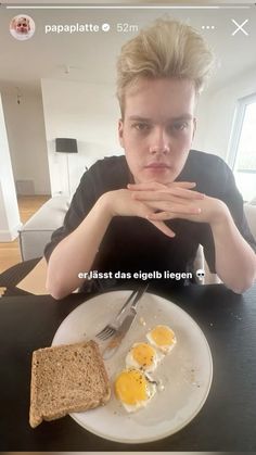 a person sitting at a table with an egg and toast on it