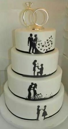 three tiered wedding cake decorated with silhouettes of two people and a ring on top