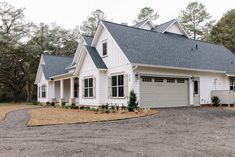 a white house with two garages in front of it