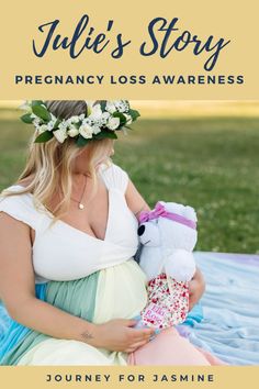 a pregnant woman sitting on a blanket holding a teddy bear and wearing a flower crown