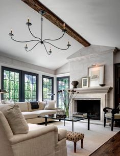 a living room filled with furniture and a fire place in front of a fireplace covered in windows