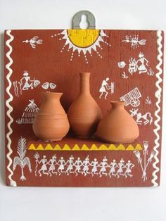 three clay vases sitting on top of a wooden plaque with native art painted on it