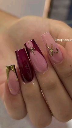 a woman's hand with pink and gold nail polishes on her nails,