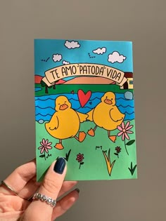 a hand holding up a card with two yellow ducks on it and the words, te amo paota vaa