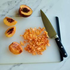 chopped up peaches on a cutting board next to a knife