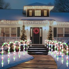 a house with christmas lights and candy canes on the front lawn