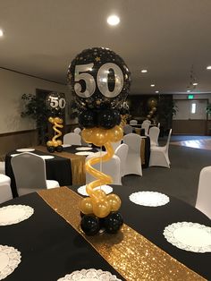 a black and gold 50th birthday party with balloons in the shape of an number 50