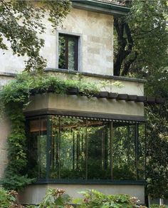 an old building with vines growing on it's side and windows in the front