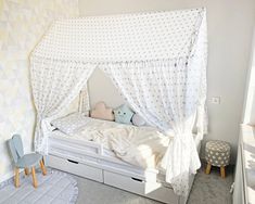 a child's bedroom with a white canopy bed